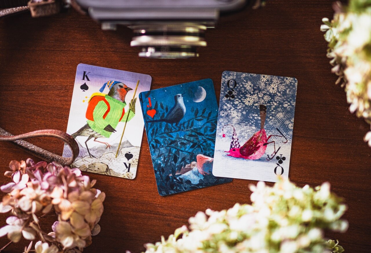 Three tarot cards on a wooden surface with flowers around
