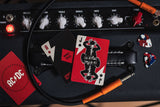 Music amplifier with playing cards and AC/DC logo on a wooden surface