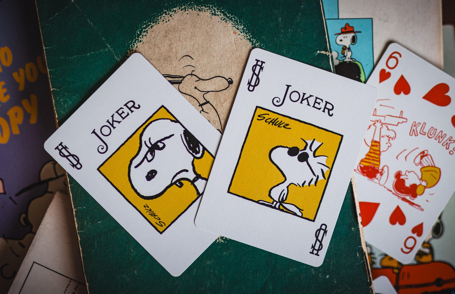 Two joker cards from a playing card set with a Snoopy illustration on a green background.