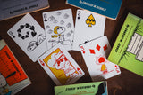 Playing cards featuring Charlie Brown and Snoopy on a wooden surface with packaging.