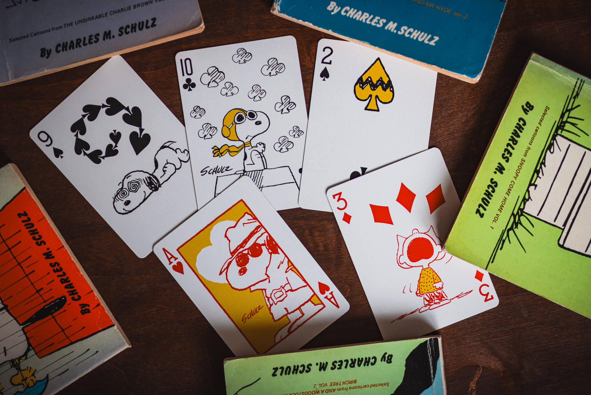 Playing cards featuring Charlie Brown and Snoopy on a wooden surface with packaging.