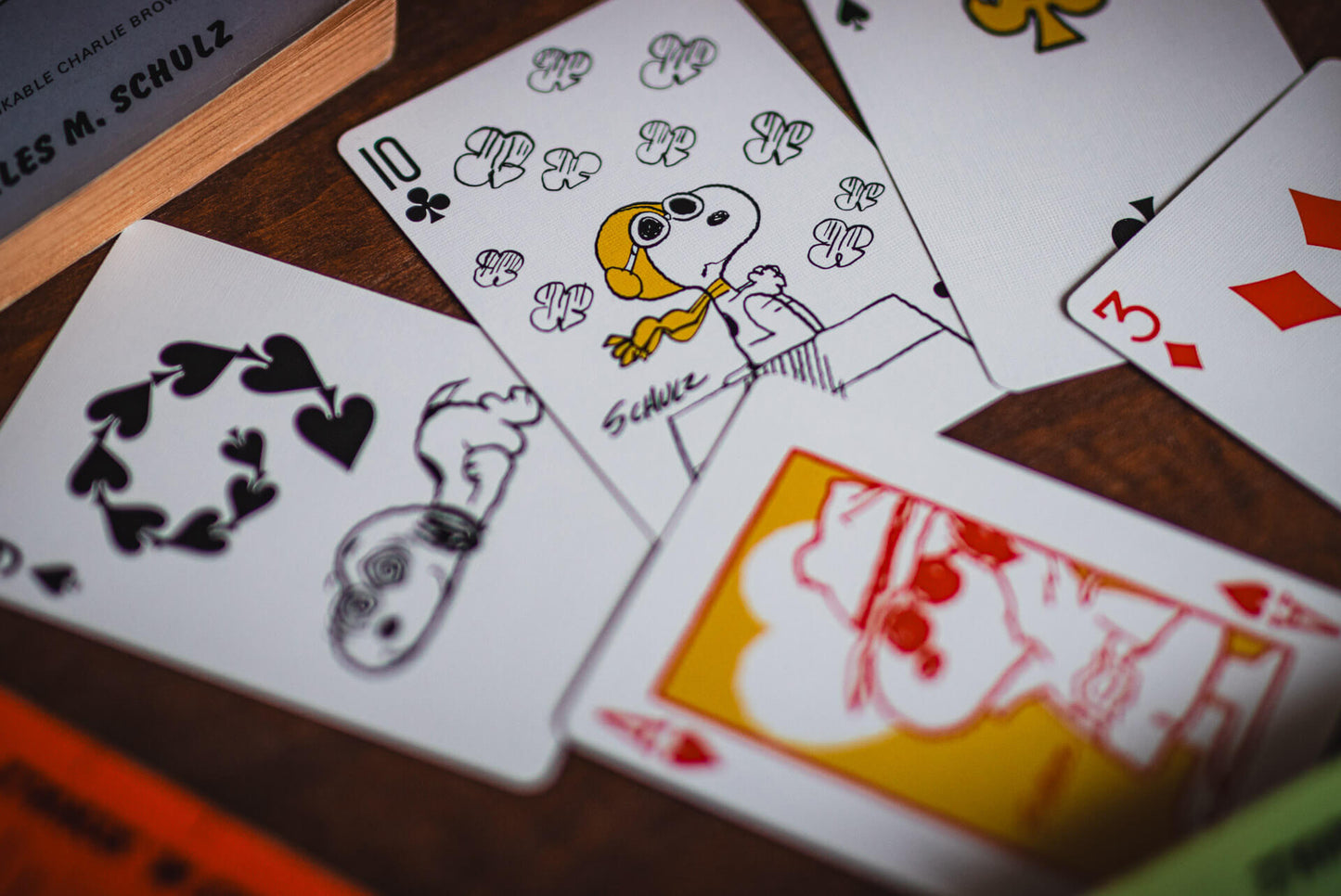 Playing cards with peanuts cartoon characters on a wooden surface