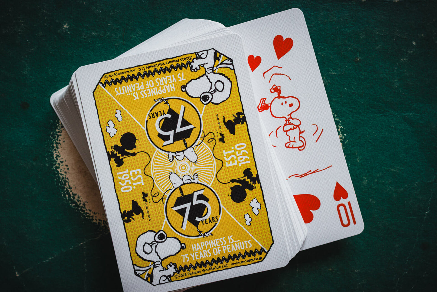 Playing cards with cartoon characters on a dark green surface