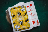 Playing cards with cartoon characters on a dark green surface