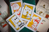 Playing cards with cartoon characters on a green surface