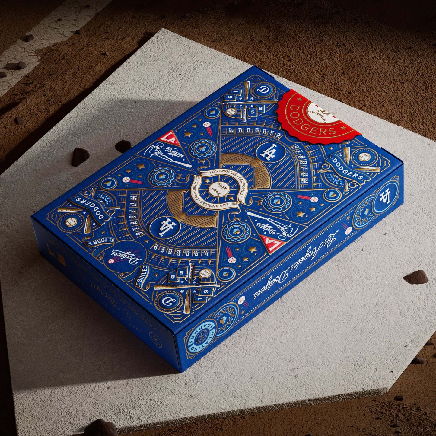 Blue packaging box with intricate designs and branding on a textured surface