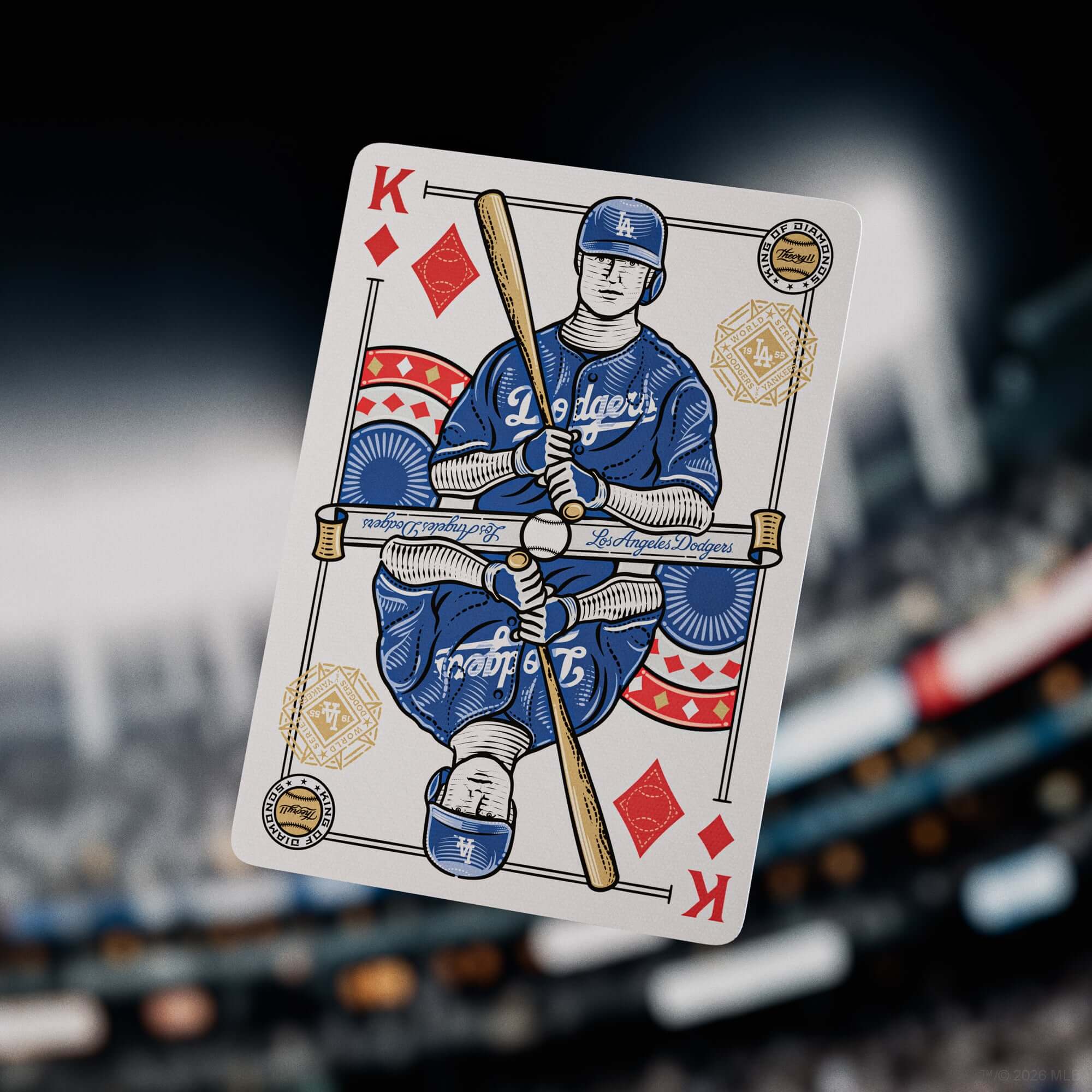 Playing card with a baseball player design, featuring the Los Angeles Dodgers logo, held in front of a stadium.